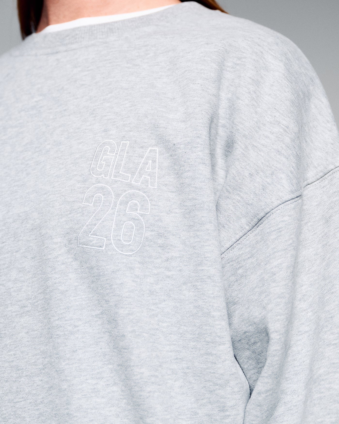 Gray sweatshirt with white text on the back against a gray background