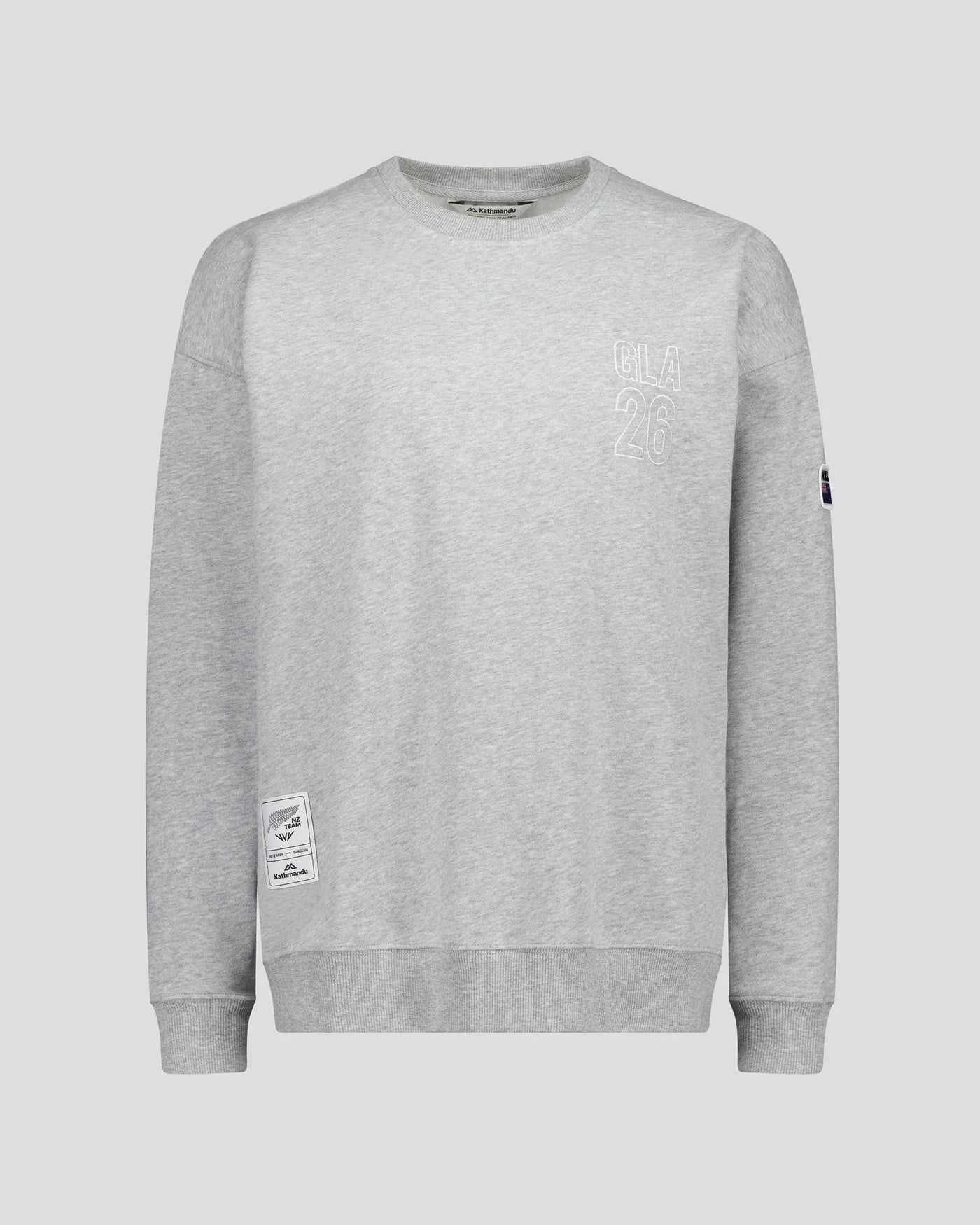 A light gray heather crewneck sweatshirt with tonal embroidered graphics on the left chest and a small black patch on the right sleeve, shown against a solid light gray background.