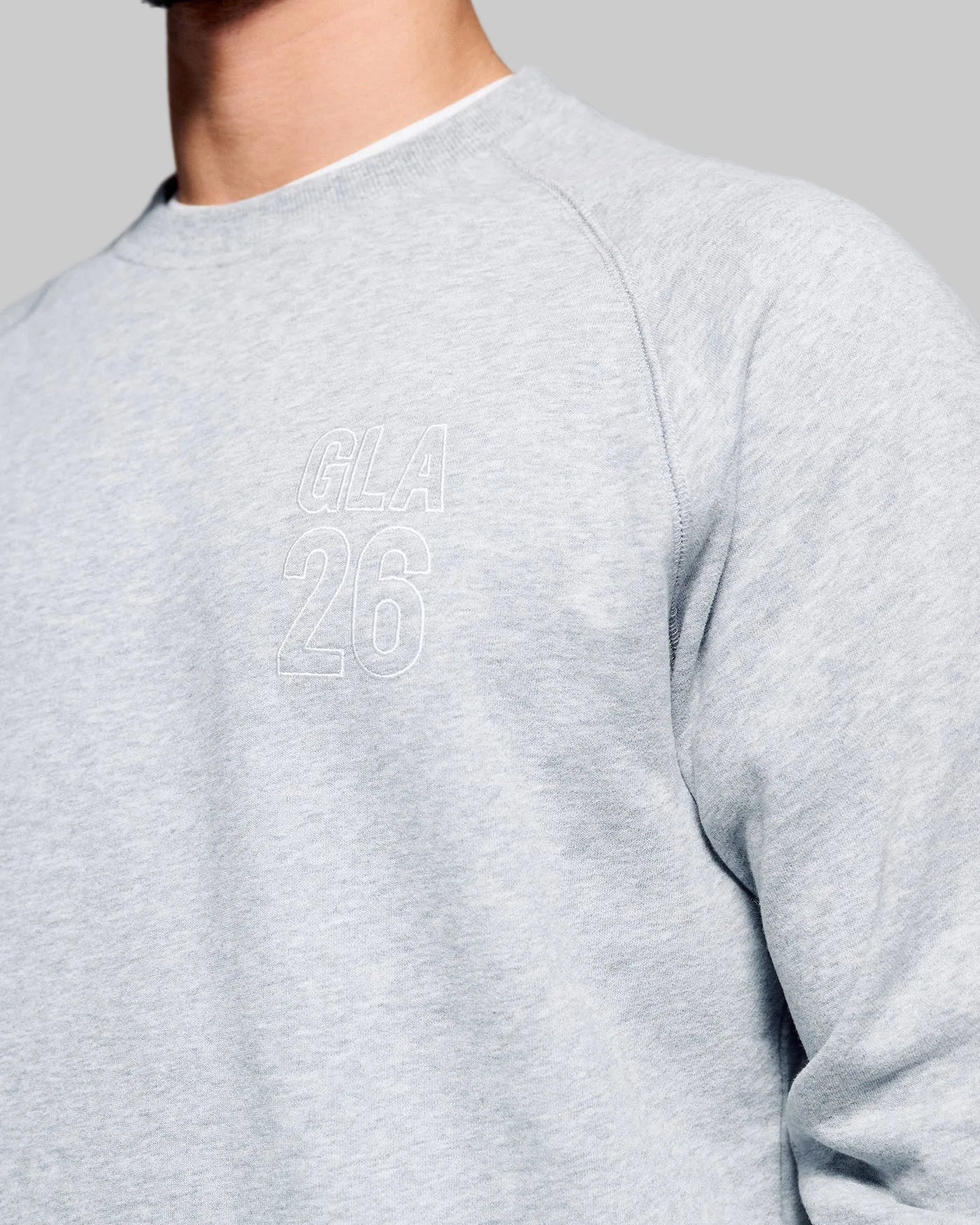 Gray sweatshirt with 'GLA 26' text on a plain background