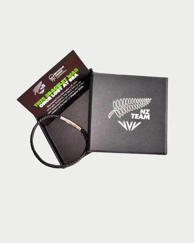Black woven NZ Team bracelet shown with packaging