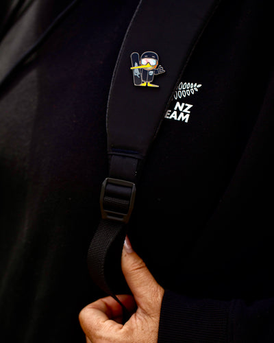 Goldie snowboarding pin on a NZ Team backpack strap