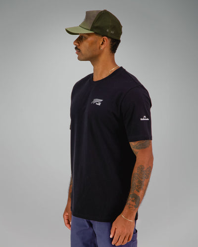 Man wearing a black t-shirt with NZ Team logo on front left side