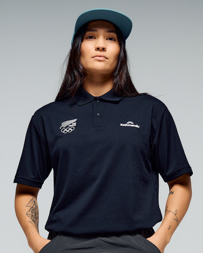 Person wearing a black polo shirt with NZ Team logo on the right hand side